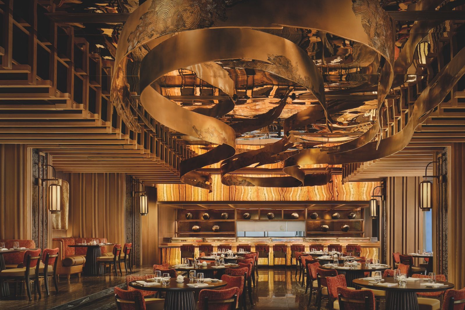 The main dining room at Nobu Bangkok features a site-specific installation of gold swirling  sumi-e ink that floats beneath a mirrored ceiling (Photo: Owen Raggatt)