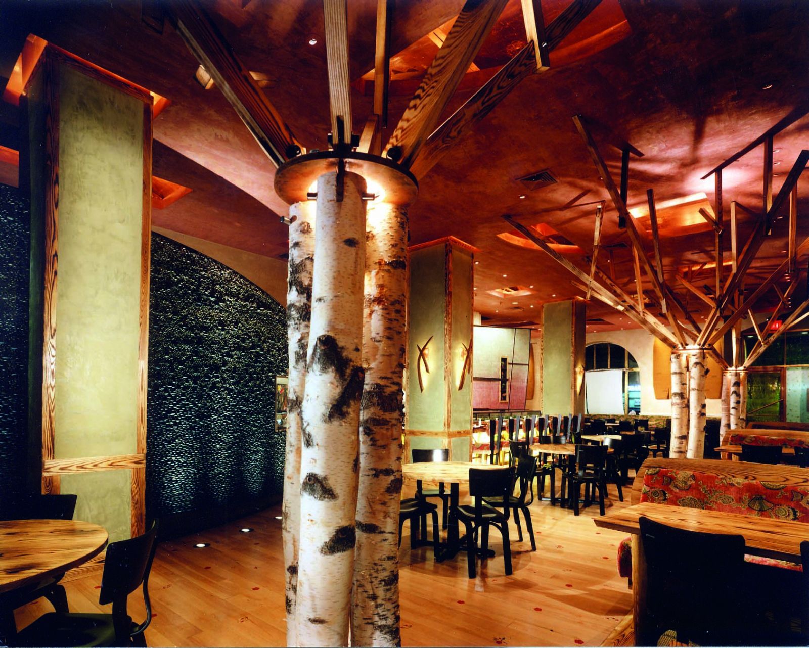 The first Nobu opened in Tribeca and featured signature birch tree columns and textured stone walls that established the brand's distinctive narrative-driven aesthetic across 40+ global locations