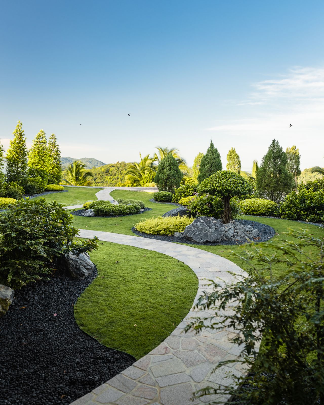 The landscape features tropical plants transformed into precise topiary, creating a fantastical atmosphere reminiscent of European gardens