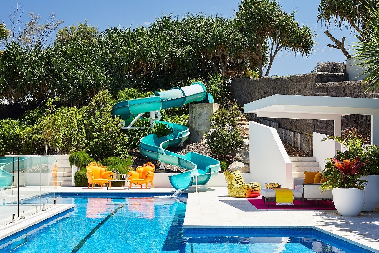 The pool area features a turquoise water slide and extravagant orange pool chairs (Photo: Alicia Taylor)