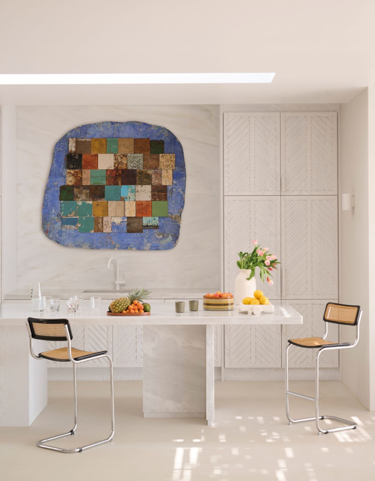 An lively artwork serves as a focal point in the neutral-hued kitchen (Photo: Alexis Armanet)