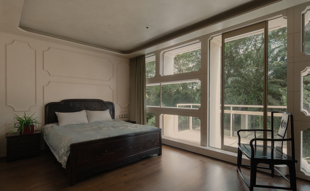 This bedroom features solid wood furniture and wainscoting that mimics the shape of the openings of the concrete-block module