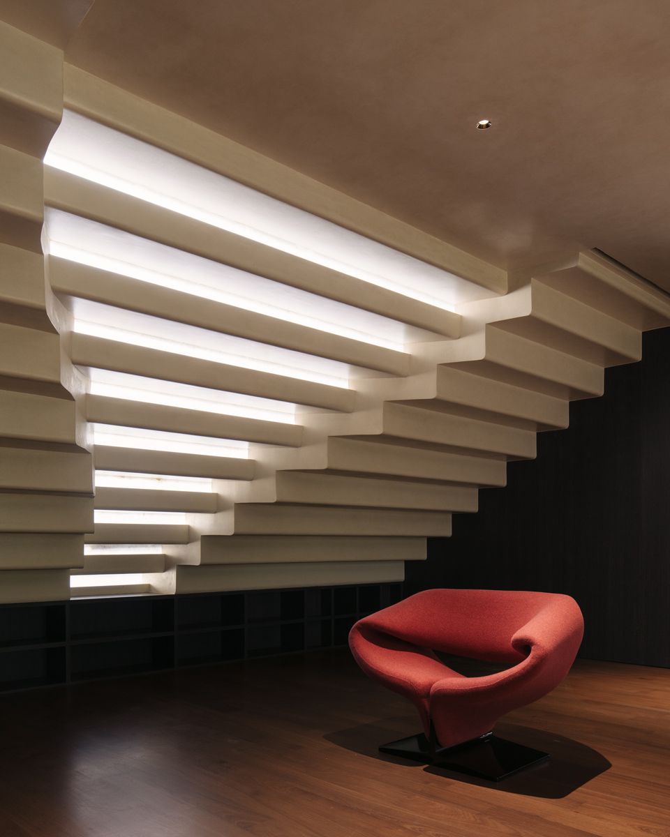 Daylight filters through the cascading water feature, illuminating the cosy reading corner in the library