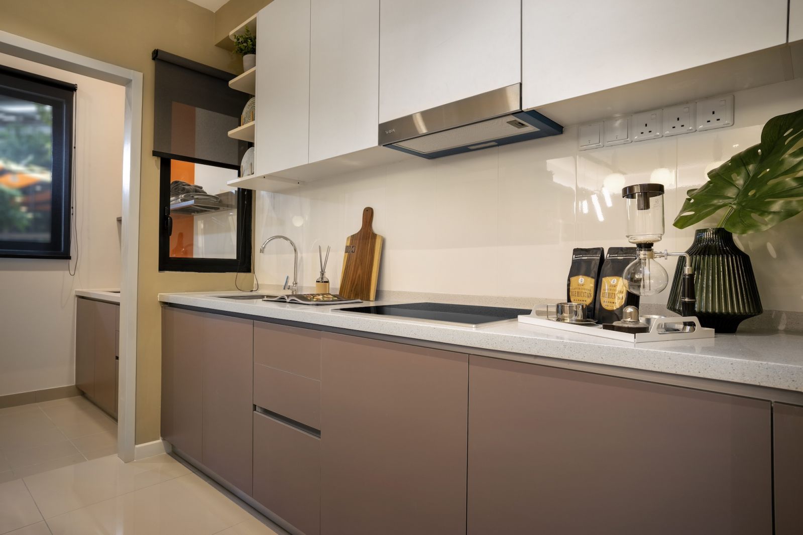 The kitchen's clean lines are emphasised by handleless cabinetry and integrated storage solutions
