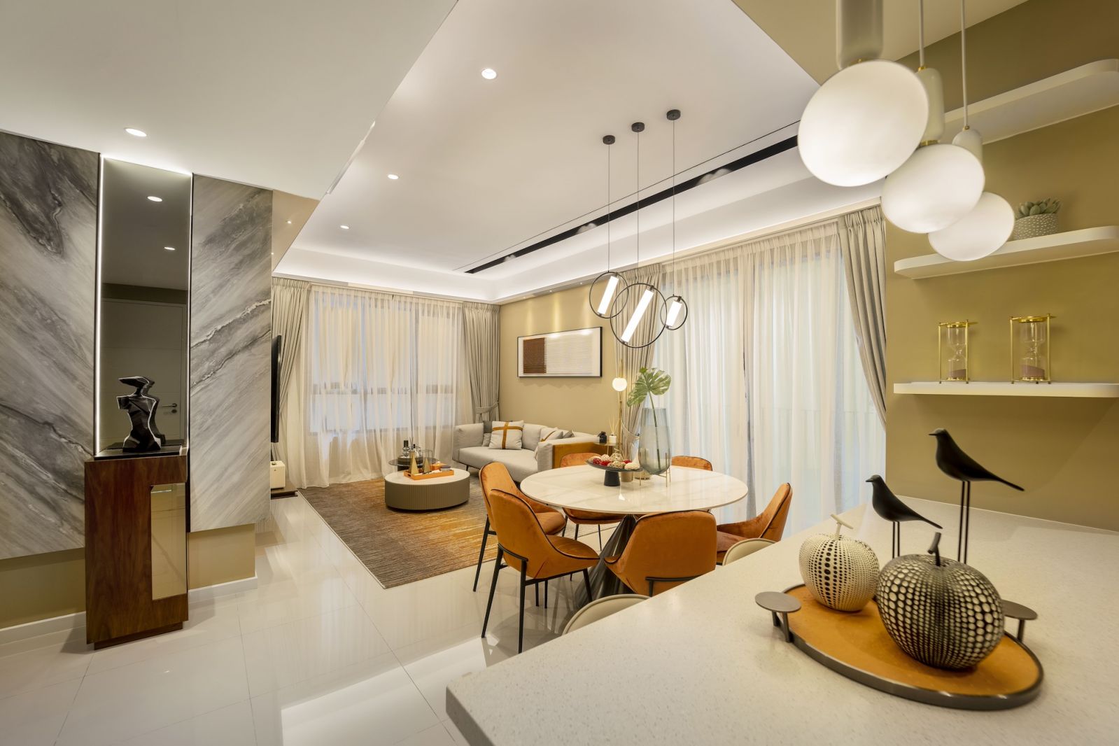 The layered lighting approach combines recessed fixtures with sculptural pendant lights to create visual rhythm throughout the 1,105-sq-ft space