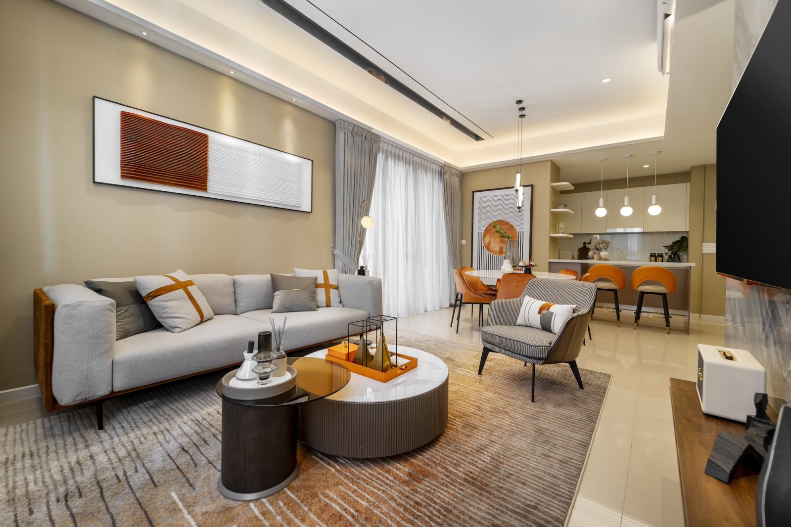 The open-plan layout's spatial flow, where consistent materials and the strategic use of orange accents create unity between living, dining, and kitchen zones within the compact footprint.