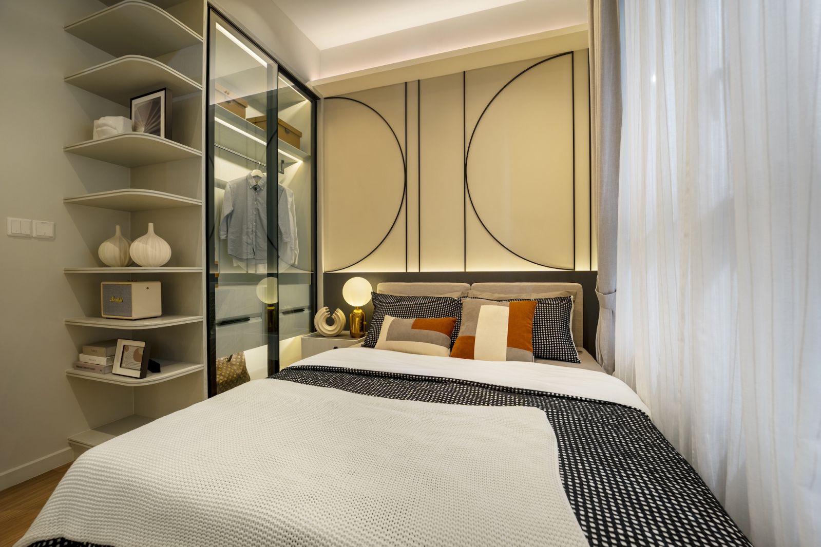 The master bedroom features a geometric panelled feature wall behind the bed with built-in wardrobes providing flush storage solutions