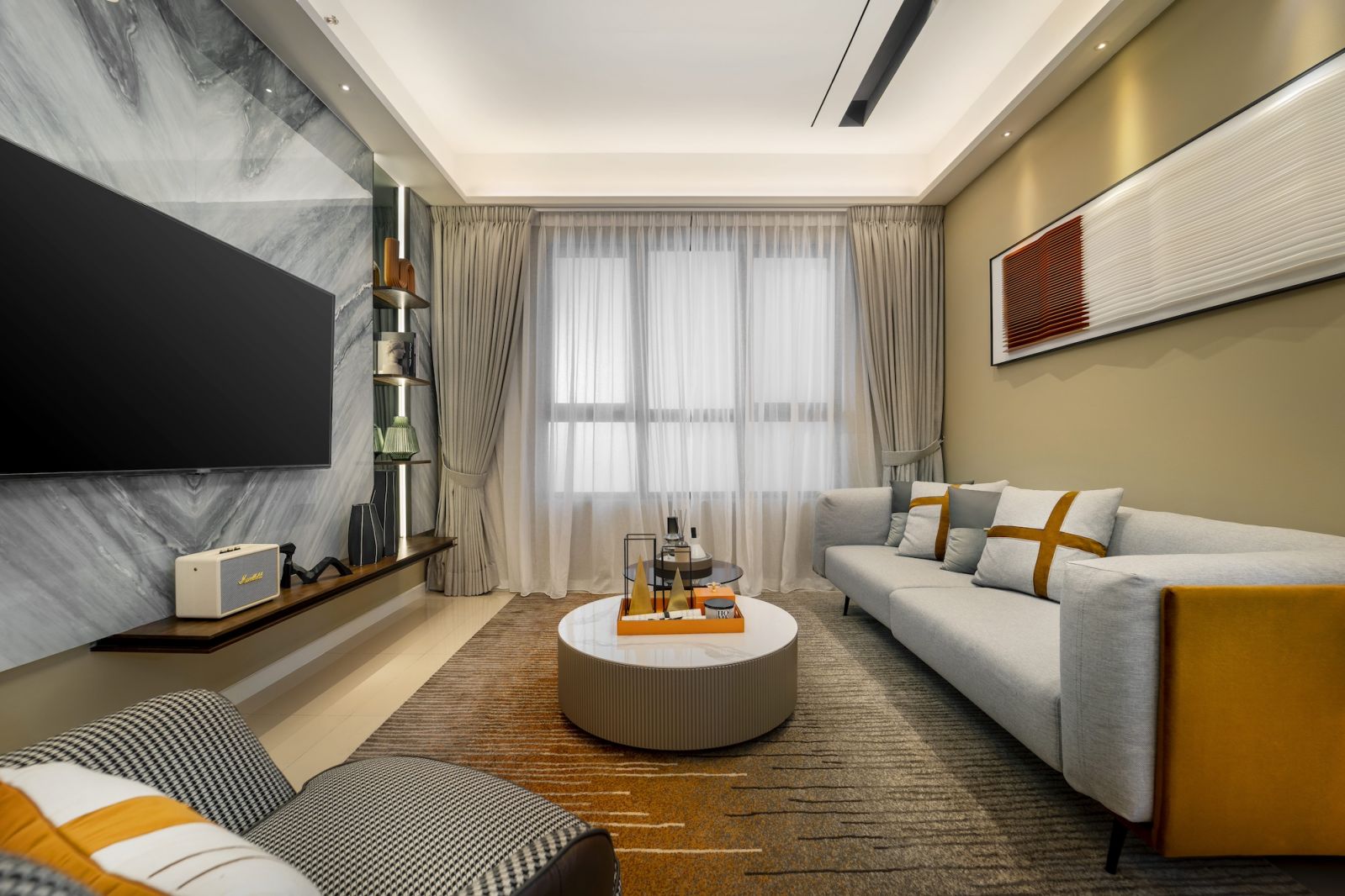 The living area showcases the unit’s layered lighting approach, combining recessed ceiling fixtures with accent lighting