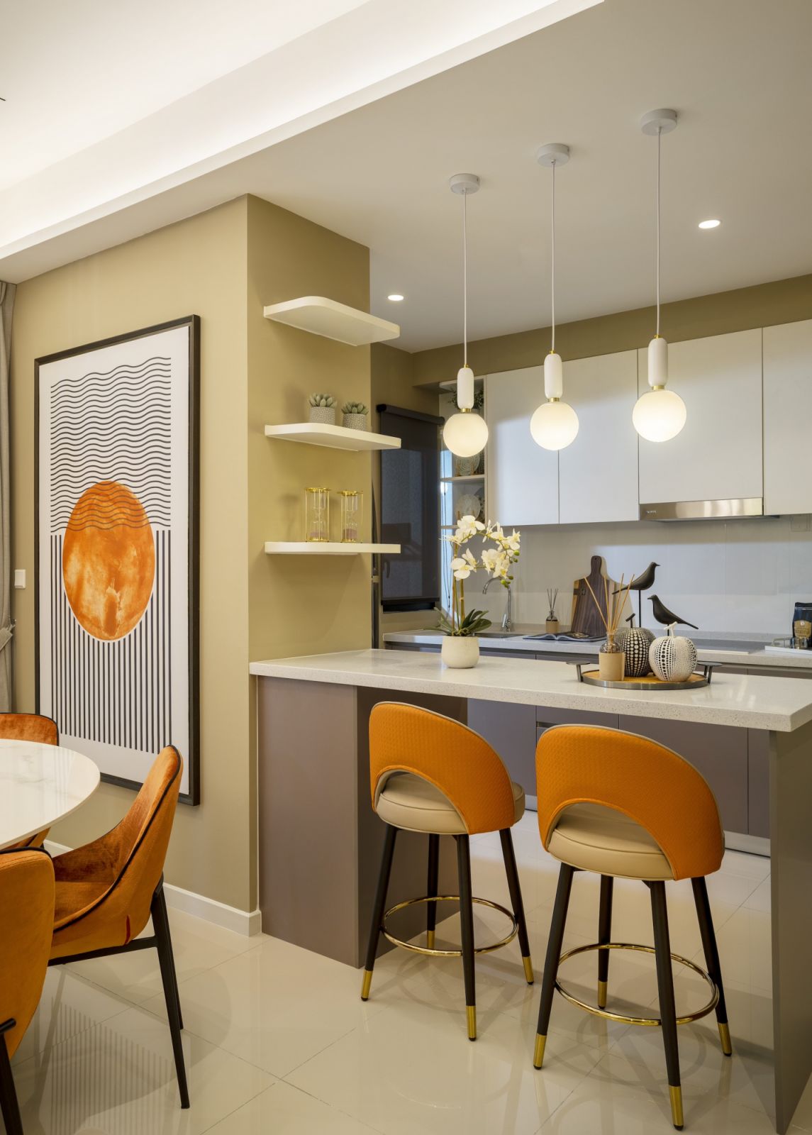 The kitchen island extends beyond its cabinetry base to form a breakfast bar, topped with marble-effect surfaces that continue the unit's sophisticated material vocabulary