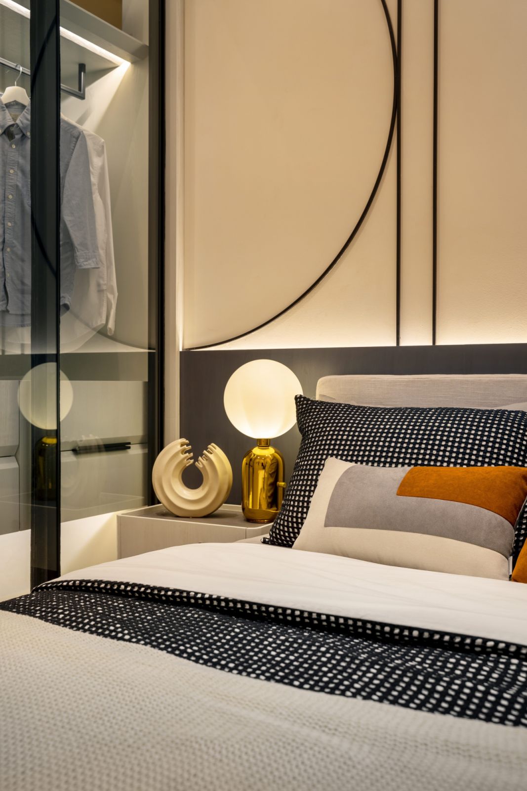 The master bedroom features geometric panelling behind the bed with built-in storage that appears integrated rather than added