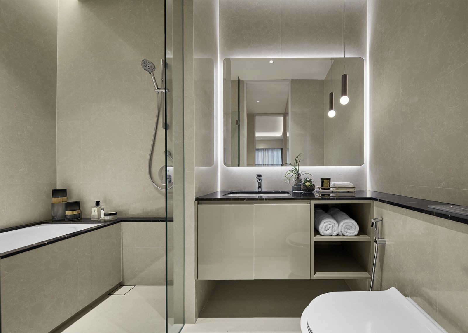 The dual-purpose bathroom serves as both powder room and guest bathroom, eliminating redundant fixtures while maintaining luxury through clean lines and efficient storage solutions.