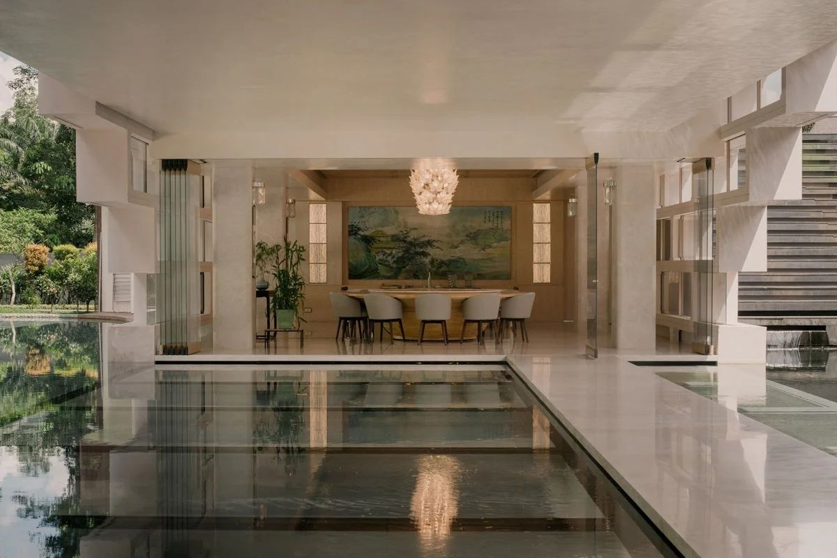 The dining room is adorned with a Chinese painting that echoes the colour palette of the forest outside