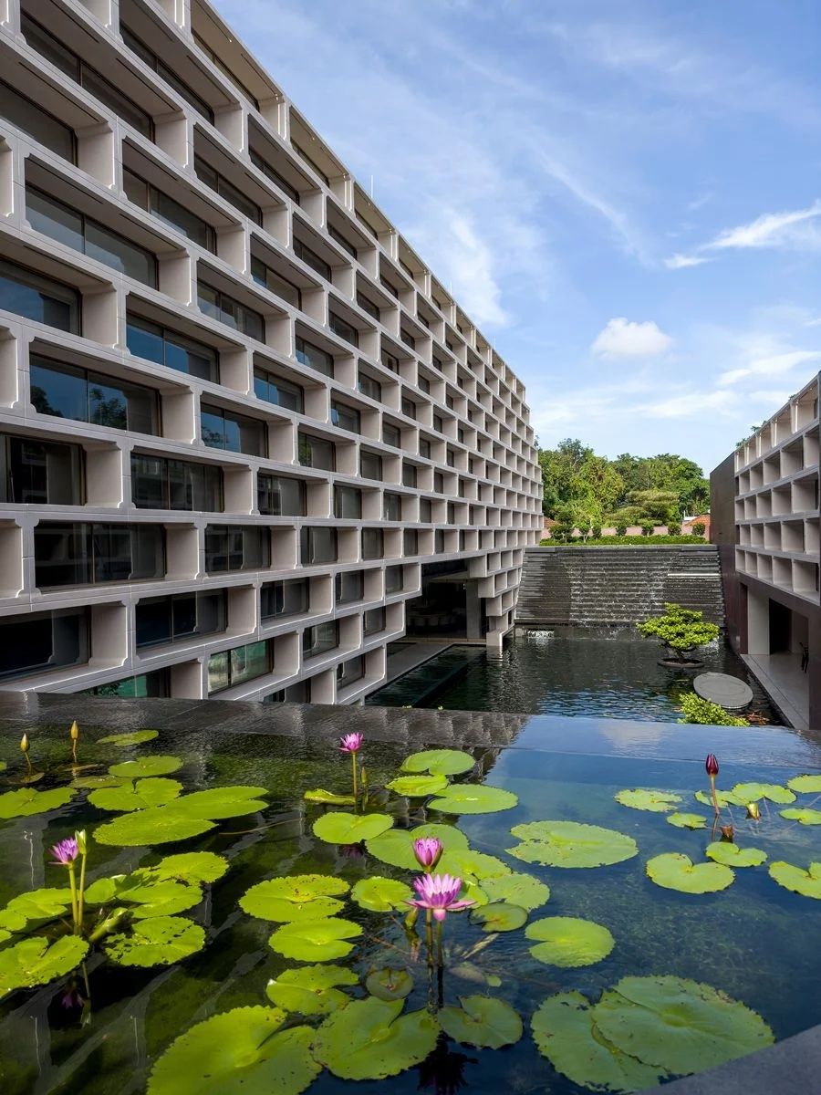 Cascading water features bracketing both ends of the architectural volumes