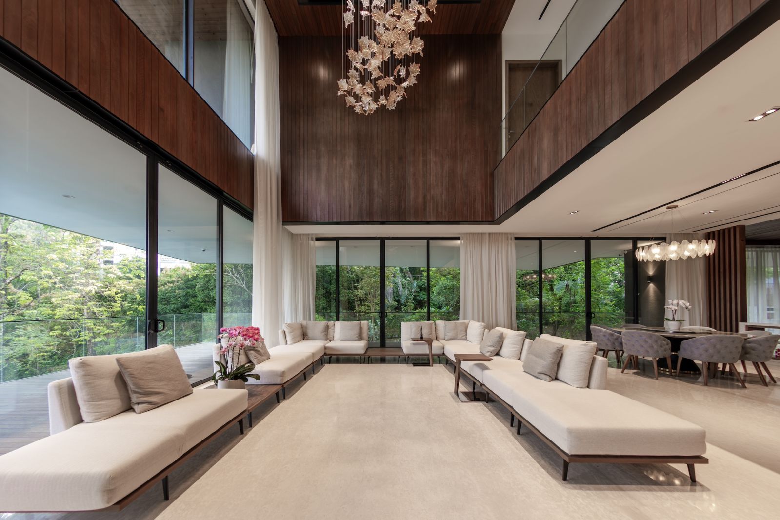 A dramatic double-volume living space where the granite feature wall contrasts against the warmth of Thermopine cladding