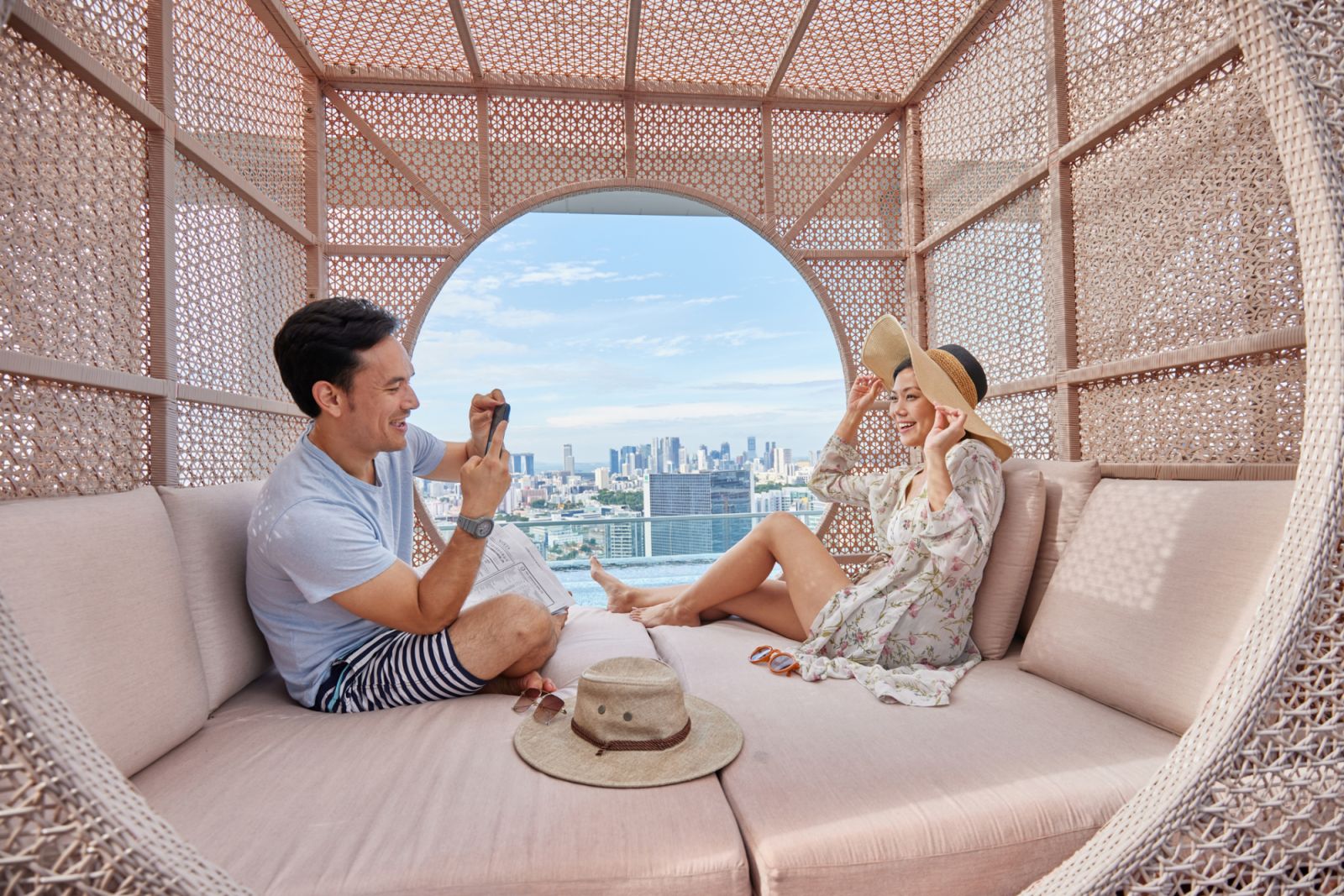 Asian couple taking photos in a cabana by hotel pool