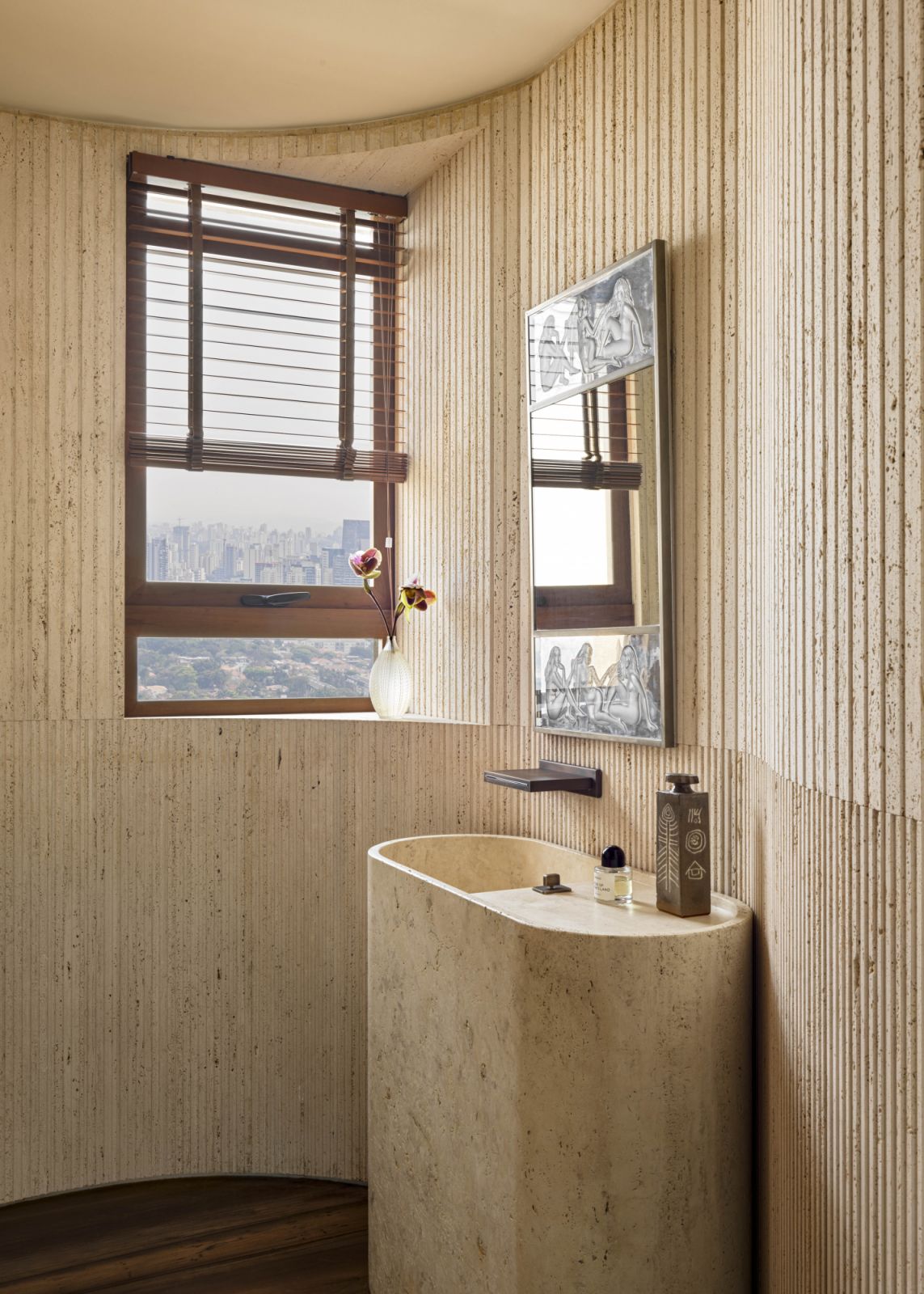 A vase by Akinori Nakatani and Lalique mirror shine in the travertine-clad powder room