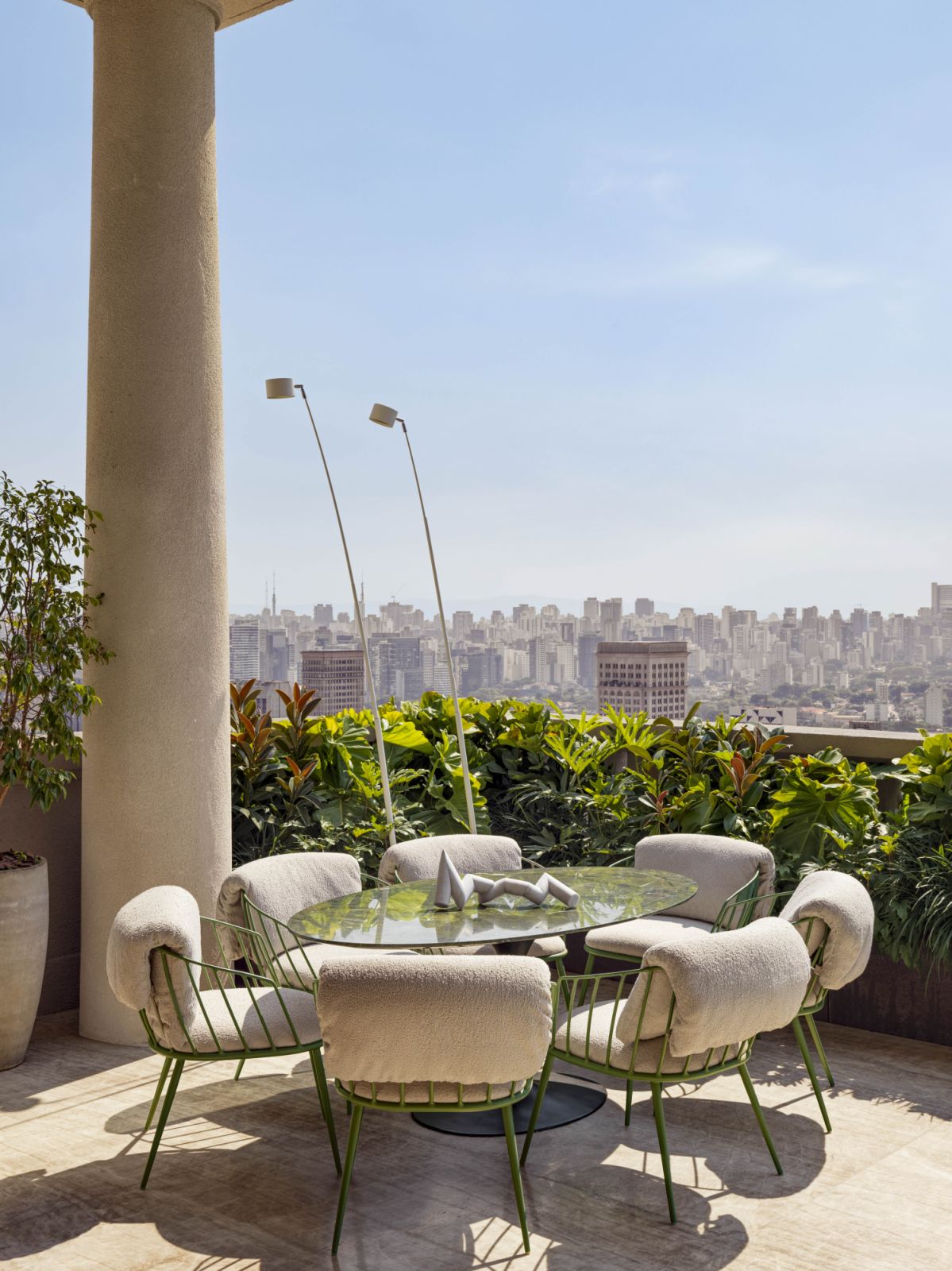 A 1970s Carrara marble sculpture by Sérgio de Camargo from Gomide&Co rests on a table by Eero Saarinen, surrounded by Alexandre Birman’s own chairs and Sampei floor lamps from Davide Groppi