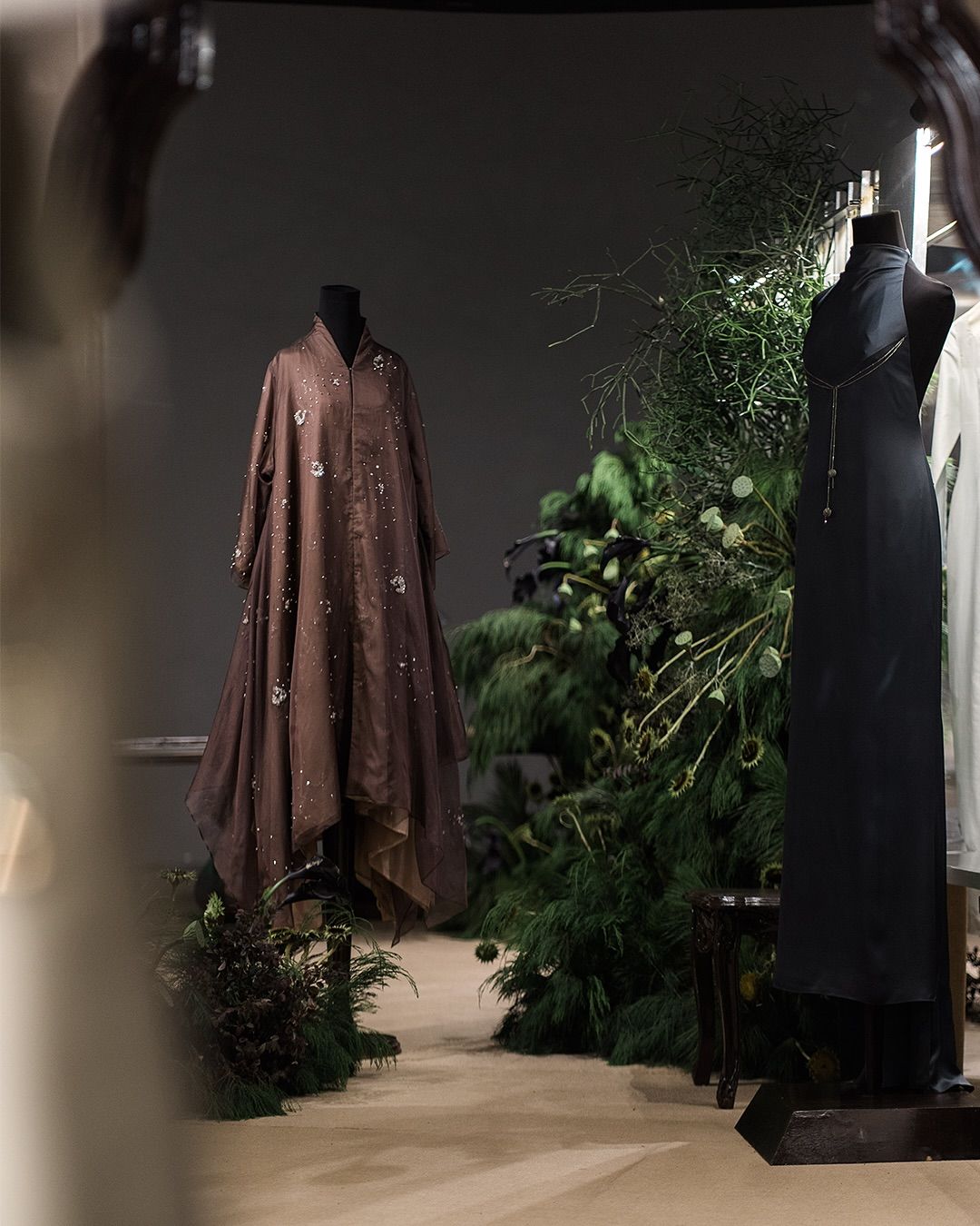 Perjalanan dimulai di Room I: Between The Woven and the Wild. Instalasi ini hadir bak sebuah tableau hidup, tempat Koleksi TANGAN Privé 2025 muncul di antara bentuk-bentuk sculptural, tekstur yang membumi, dan pertumbuhan organik yang menjalar bebas (Foto: TANGAN Privé)