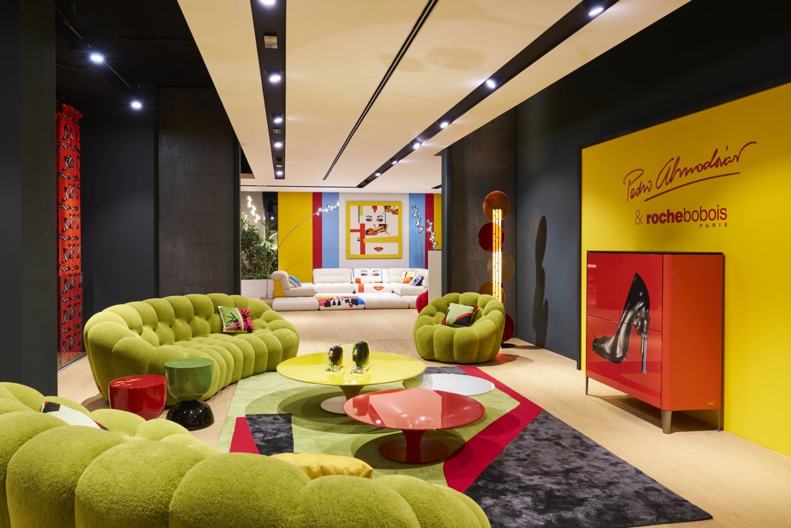 Striking green Bubble sofas line this corridor at the Roche Bobois Milan showroom