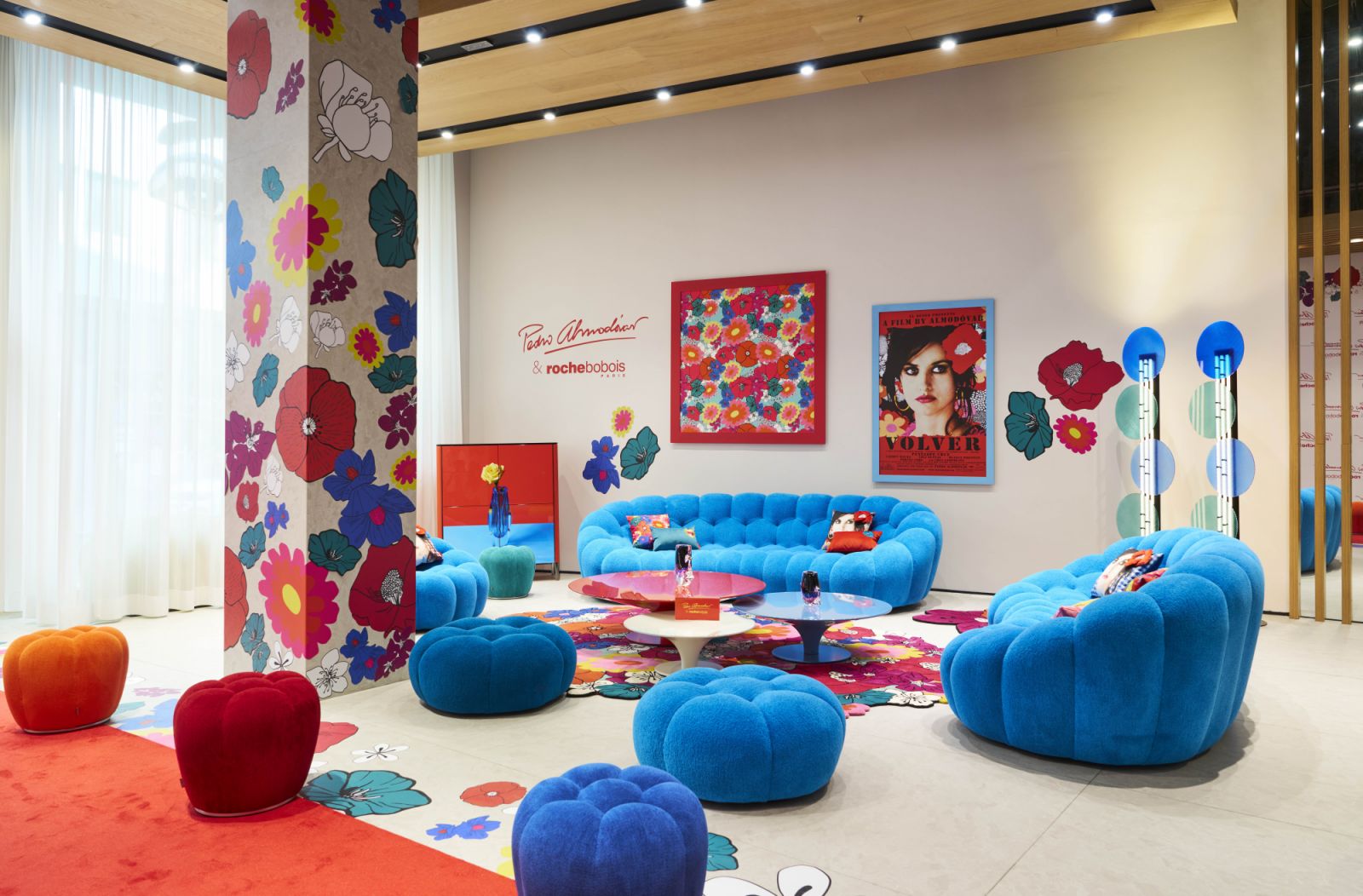 Visitors entering the Roche Bobois showroom were greeted by a vibrant scene anchored by a bright blue Bubble sofa and a floral rug inspired by the film Volver