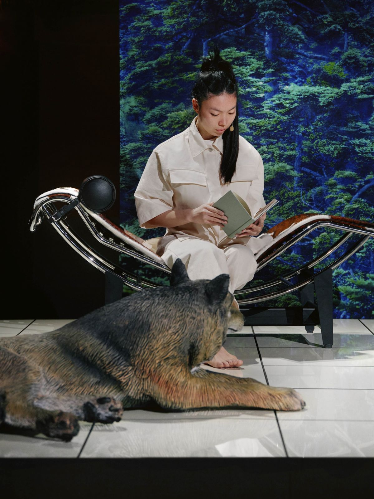 A perfomer interacting with furniture and animal statue during “Staging Modernity” at Milan Design Week 2025