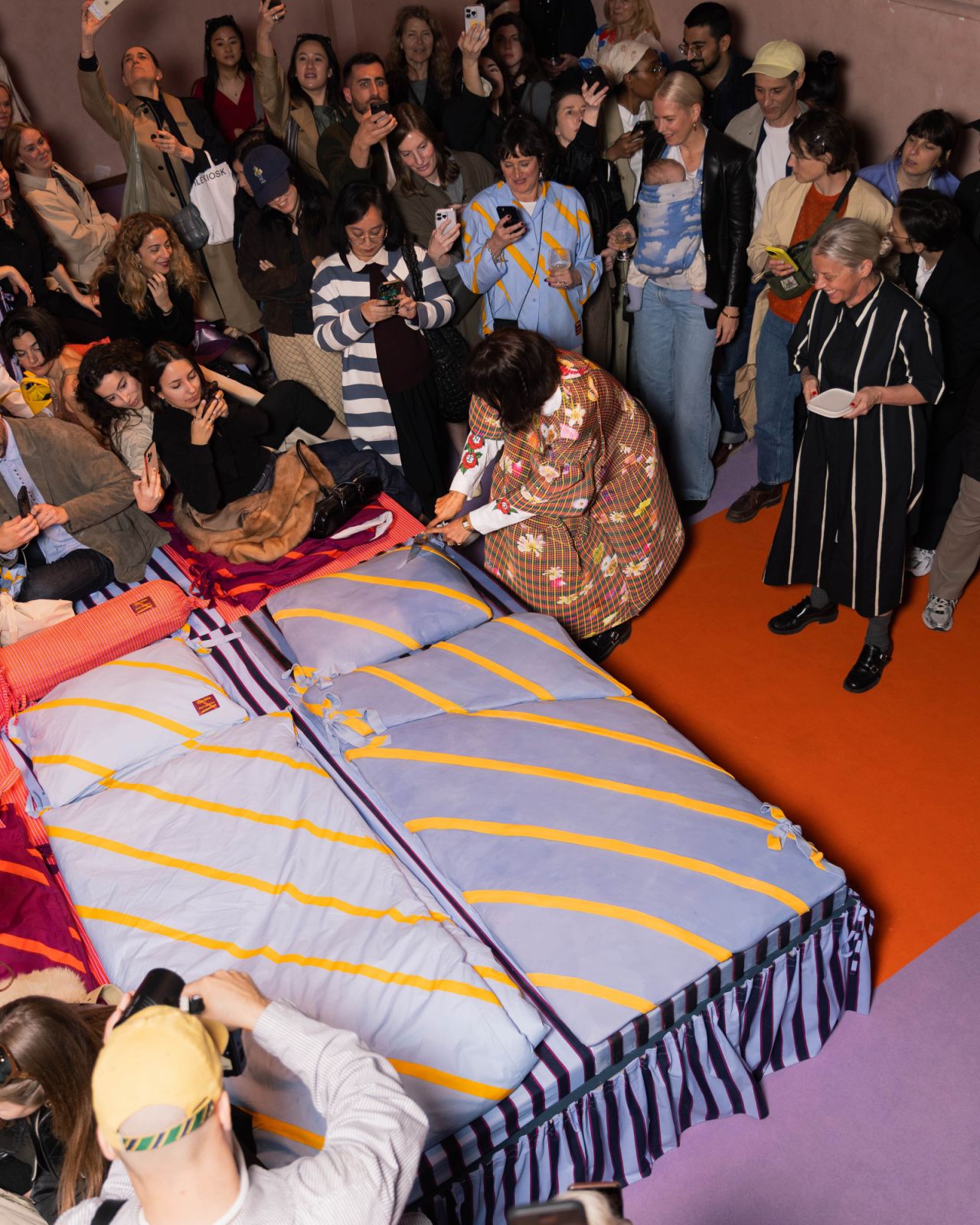 Laila Gohar cutting a bed-sized cake at the Marimekko party during Milan Design Week 2025
