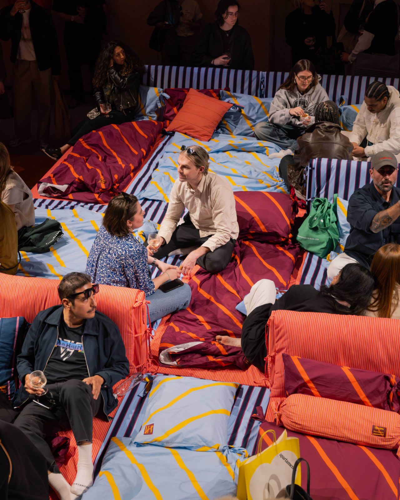 Fairgoers lounging at Marimekko’s All the Things We Do in Bed installation during Milan Design Week 2025