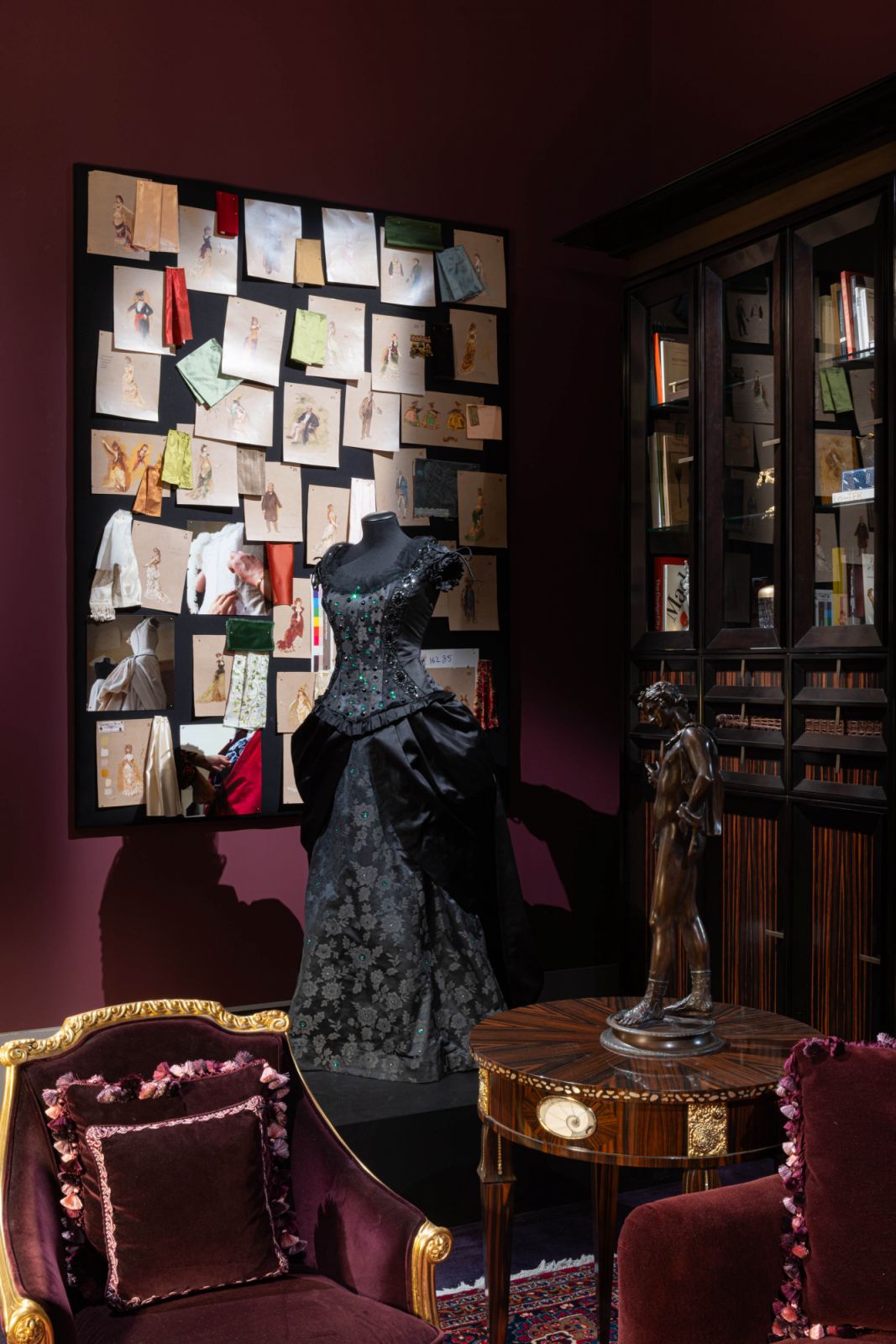 A corner of the plum library was imagined as a modiste’s workshop, complete with dress forms and a sense of storied elegance stitched into the scene
