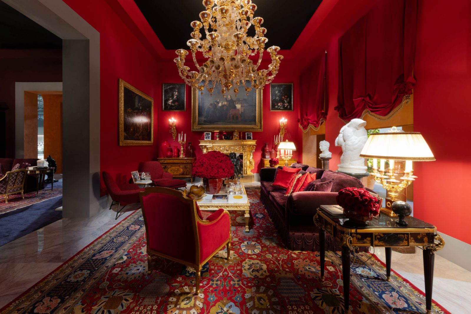 A red baroque drawing room with gilded detailing radiated drama and decadence