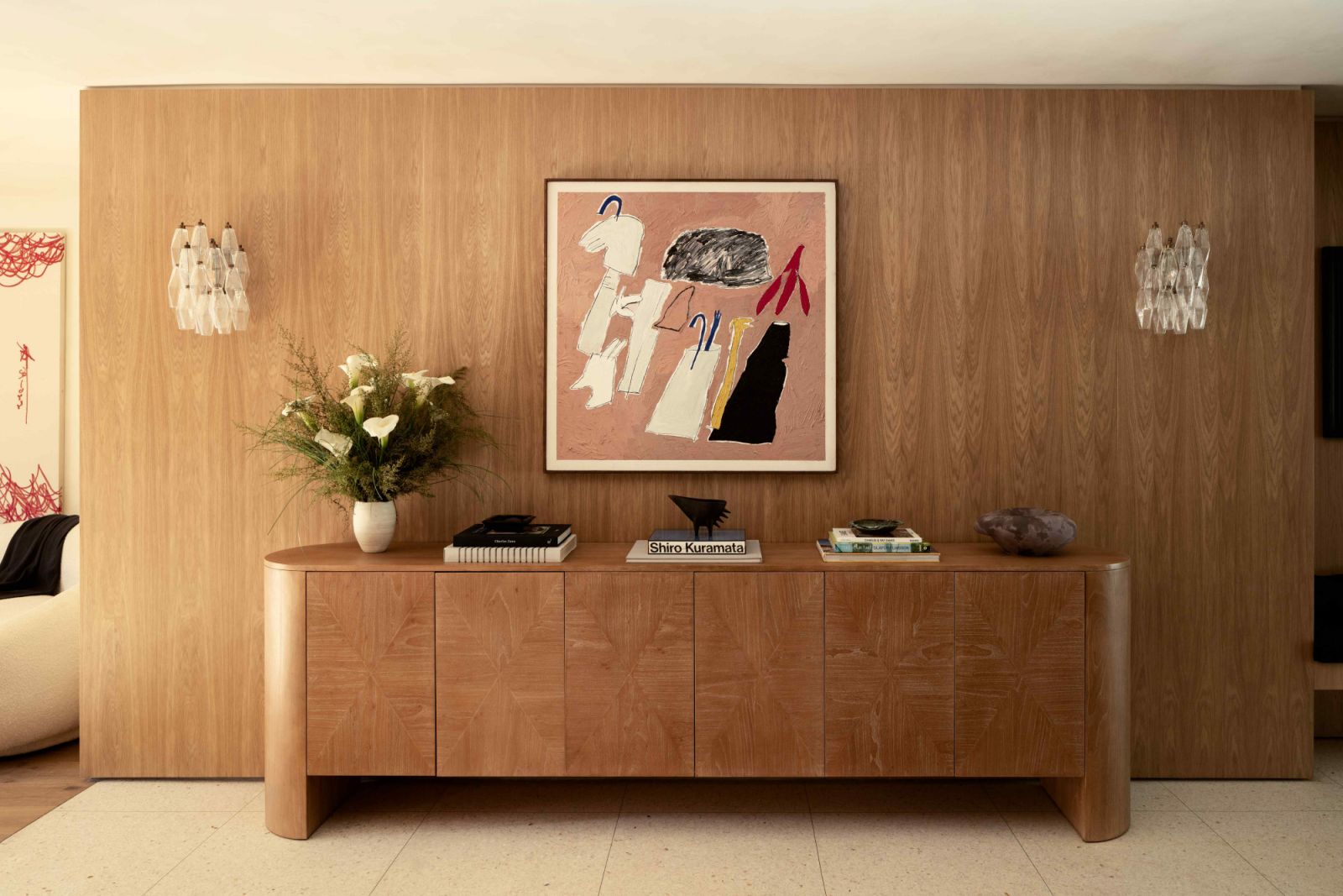 The entryway clad in white oak panelling with pops of vibrant pink