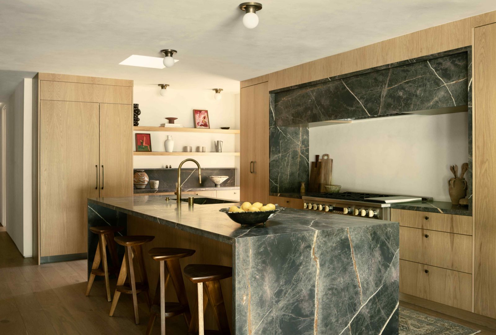 The spacious Bronze Fantasy marble island amidst custom oak cabinetry in the kitchen