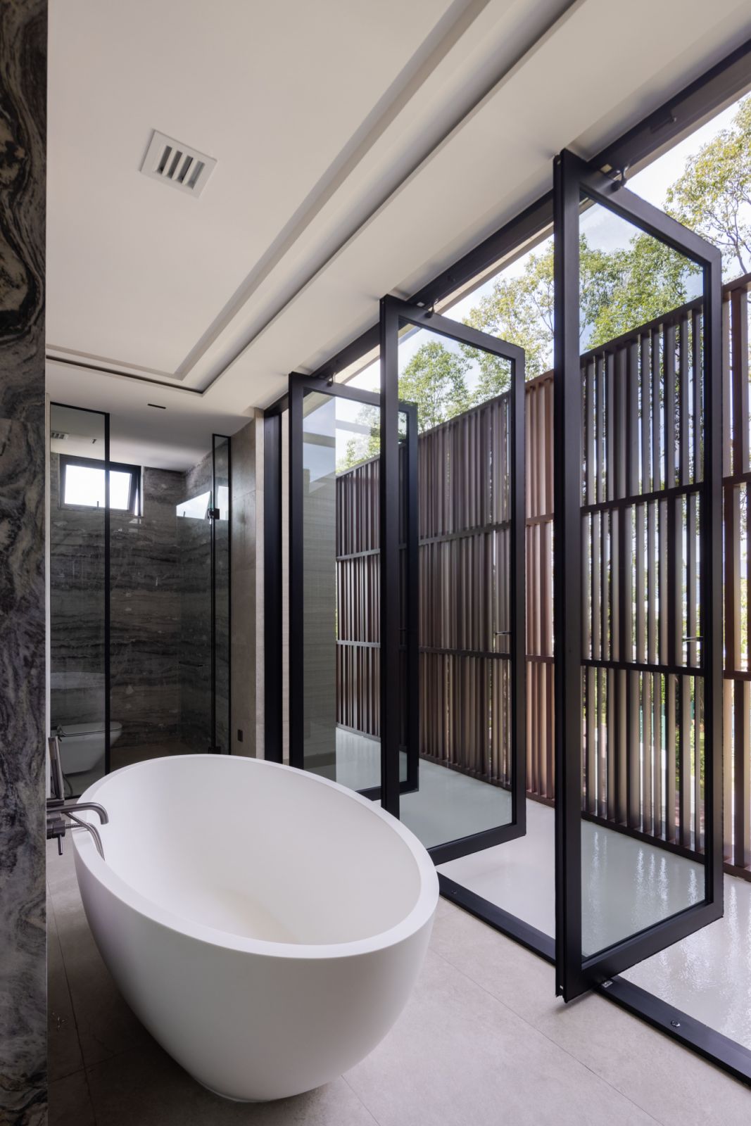 Strategic placement of openings and screens allows for an almost outdoor bathroom experience