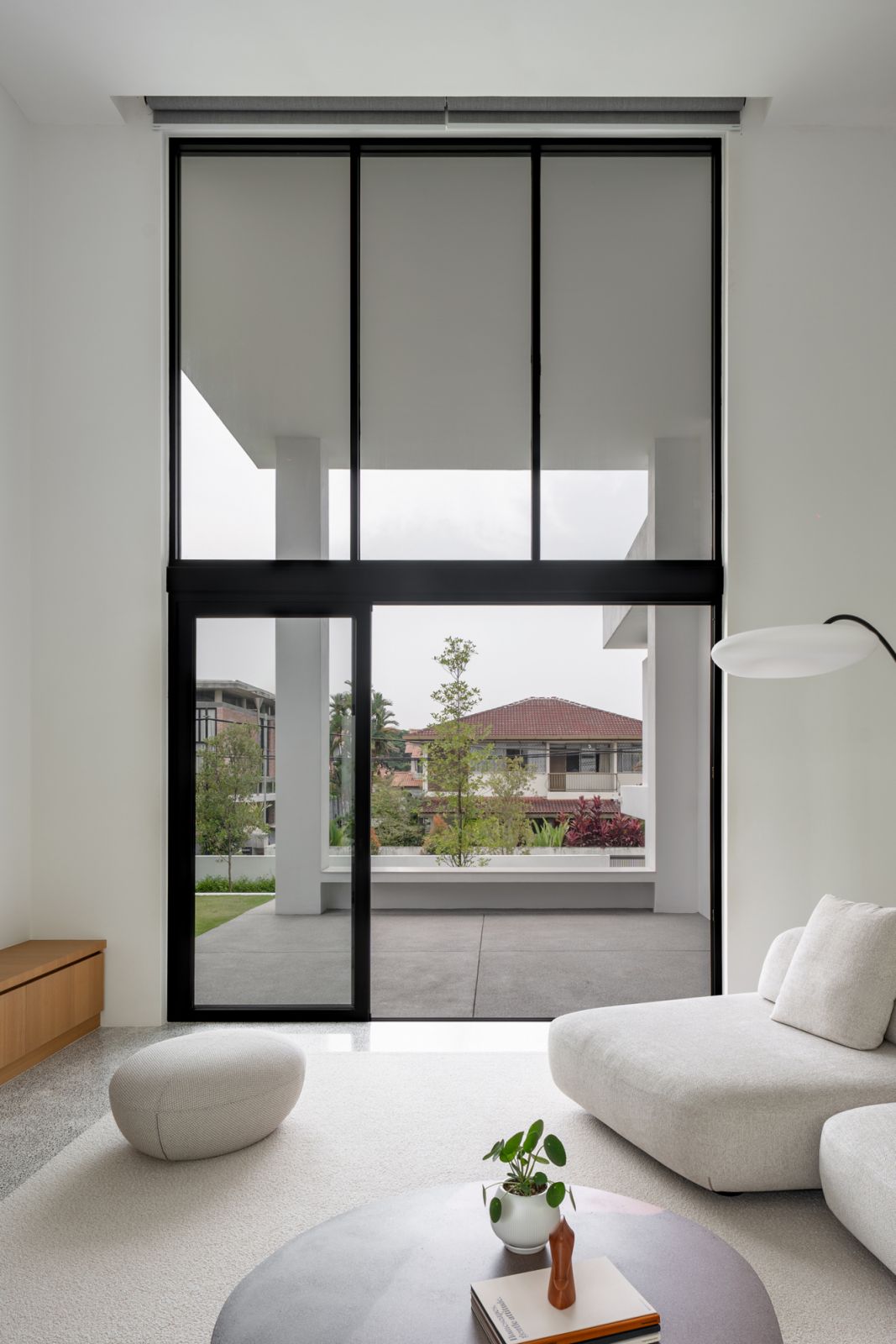 Innovative pivot door system above sliding entrance in Malaysian bungalow renovation provides four configurations for privacy, light, and ventilation control from neighbors