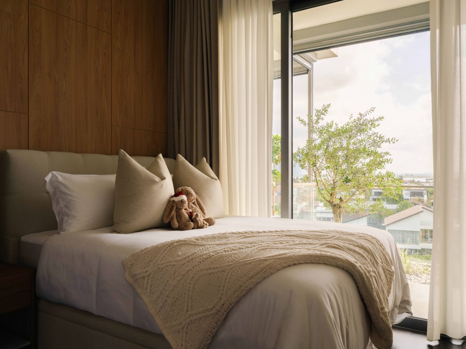 In the daughter’s bedroom, a woodgrain wall and curtains soften the space