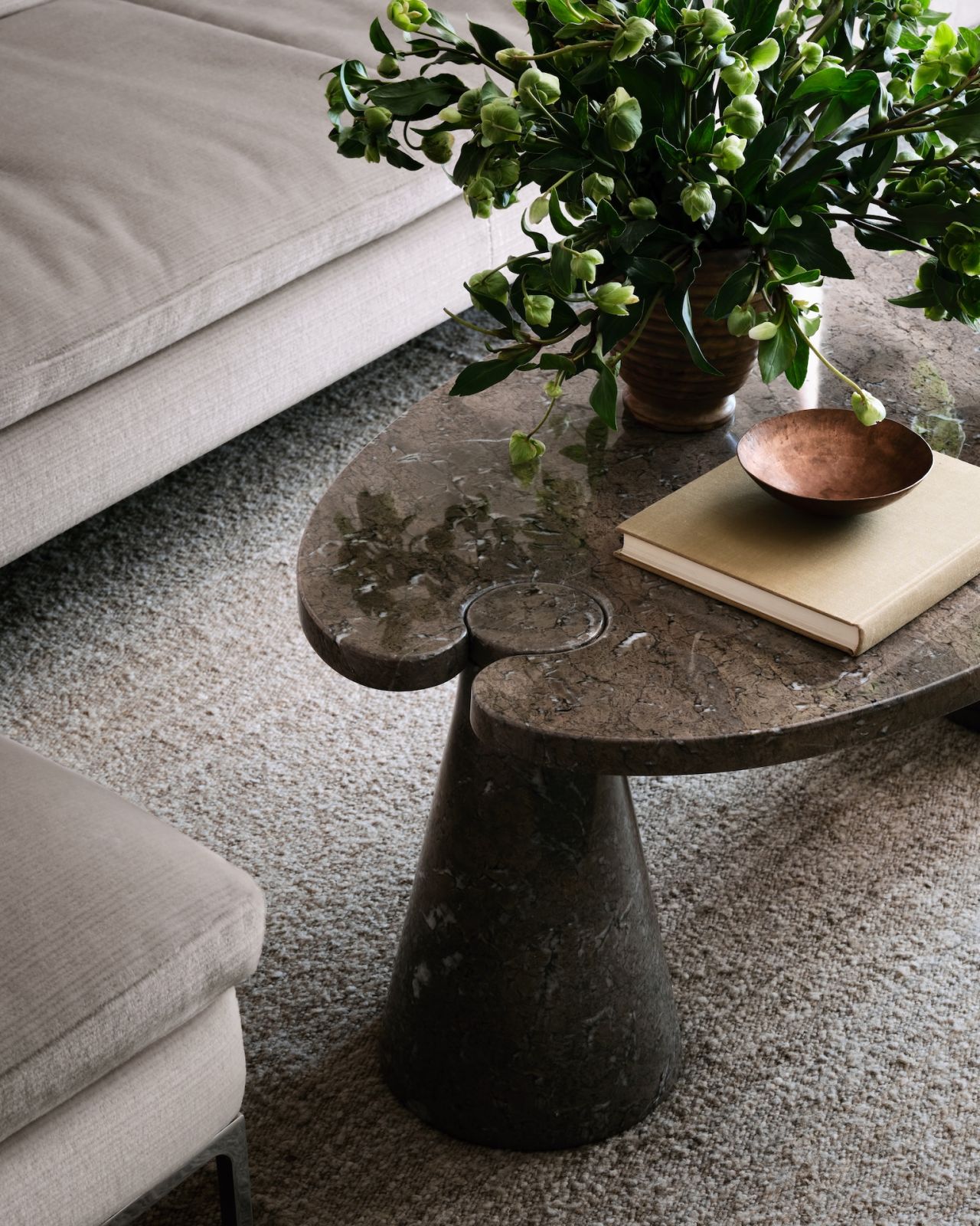 A close-up of the Angelo Mangiarotti coffee table carved out of mondragon stone in the living room of a restored warehouse in the West Village, Manhattan, New York; the home was designed by Grisoro Studio