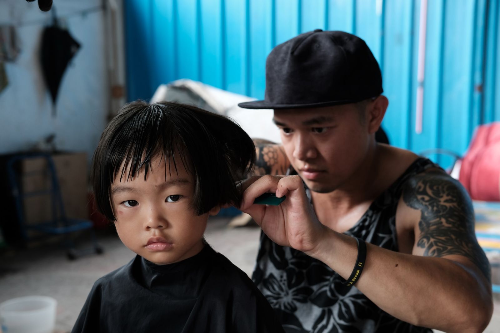 Hairstylist Mark Bustos giving a haircut to a child