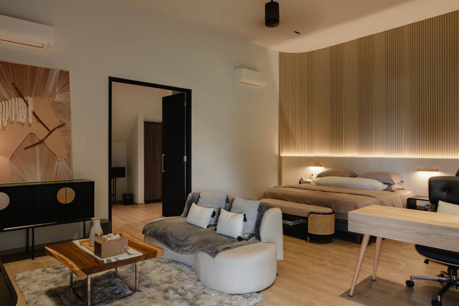 The open-plan master bedroom has a sitting area and a study