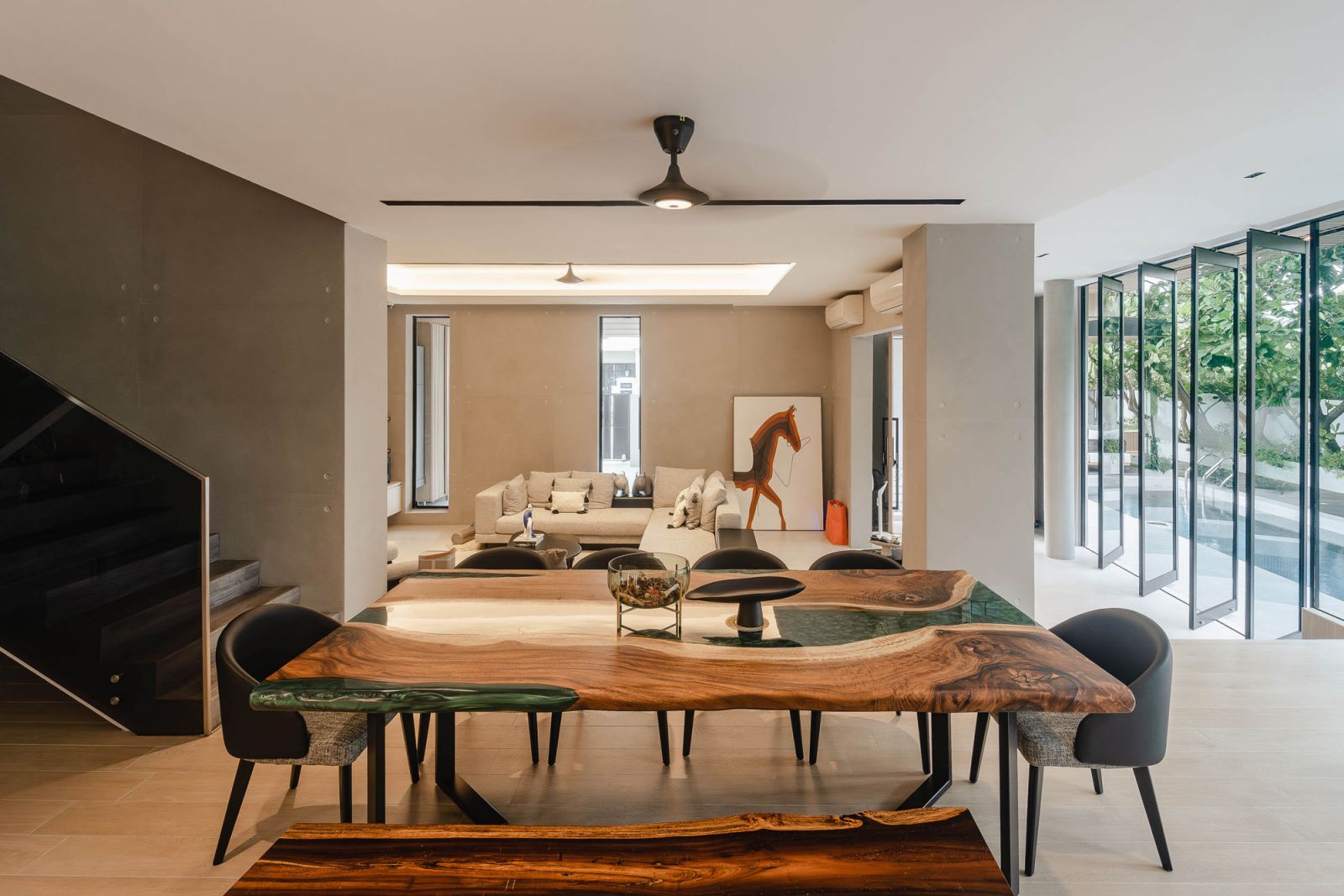 The dining table’s timber top features resin detailing that mimics flowing water in the home
