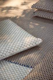 The intricate weave pattern of Alejandra Gandía-Blasco Lloret’s Nomad Tuareg Rug Blue from Gan Rugs shows how eco-conscious materials can elevate design while maintaining weather resistance.