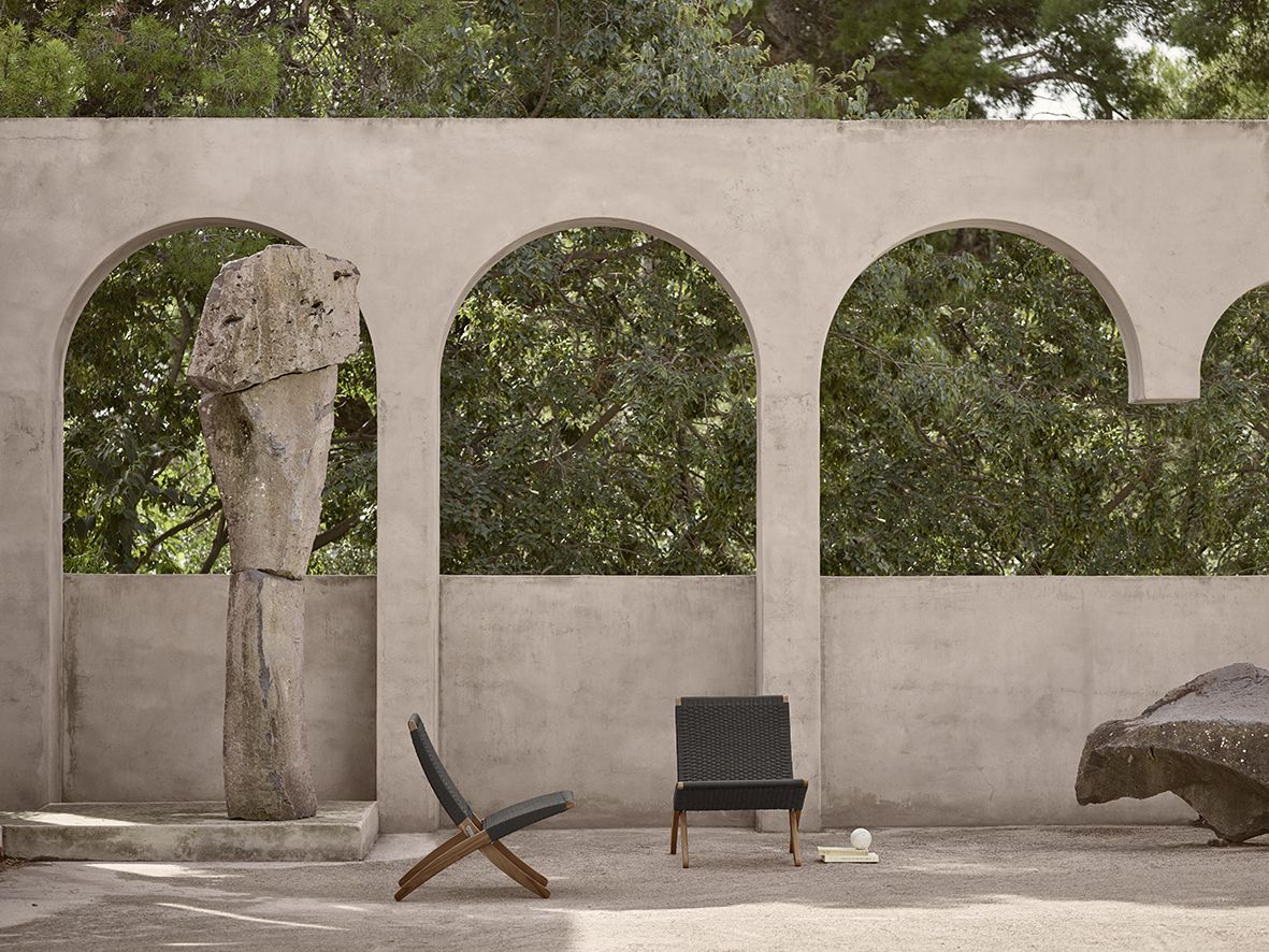 Architectural arches frame verdant greenery, demonstrating how strategic integration of plant life and natural light transforms urban environments into restorative spaces enhanced by Carl Hansen & Søn’s MG 501 Cuba Chair
