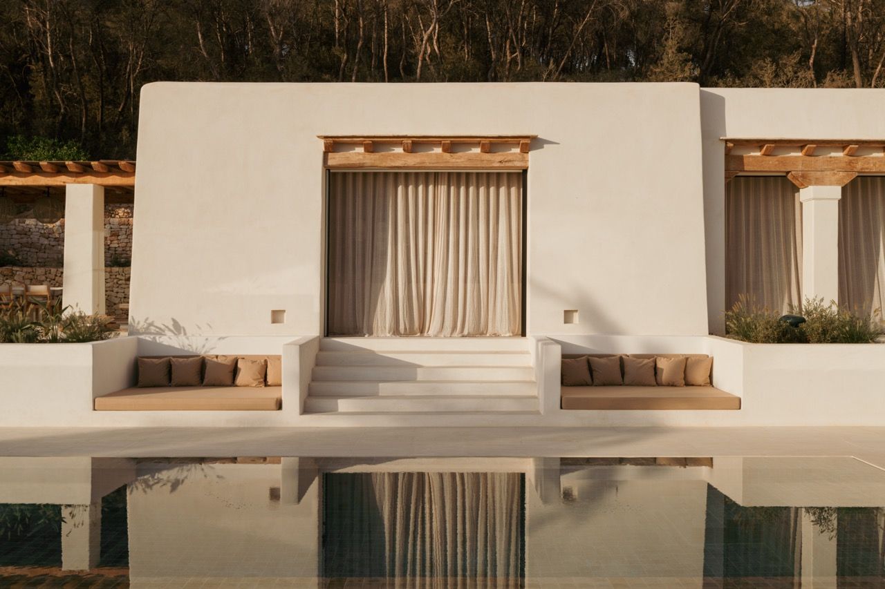 The pool terrace’s built-in seating and traditional column details create outdoor rooms perfectly scaled for entertaining, with the home’s clean lines reflected in the still water