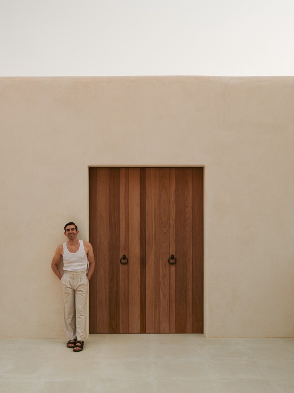 The entrance facade showcases the collaboration between Blakstad architects and Natural Asthetik, with Tom Lawrence-Levy positioned beside the handcrafted wooden doors