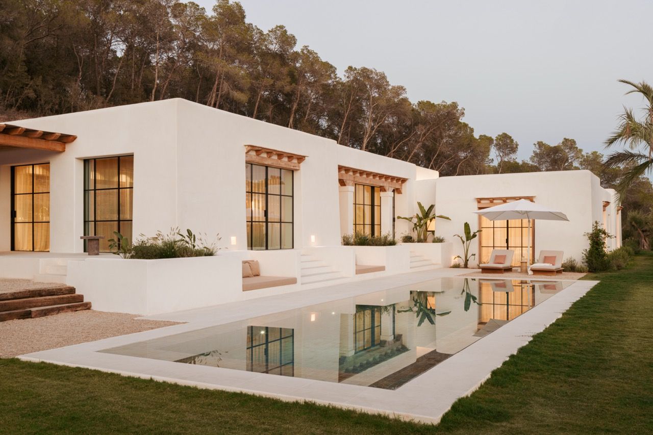 The completed house at dusk demonstrates the successful collaboration between Blakstad architects and Natural Asthetik, with warm interior lighting highlighting the seamless integration of indoor and outdoor living