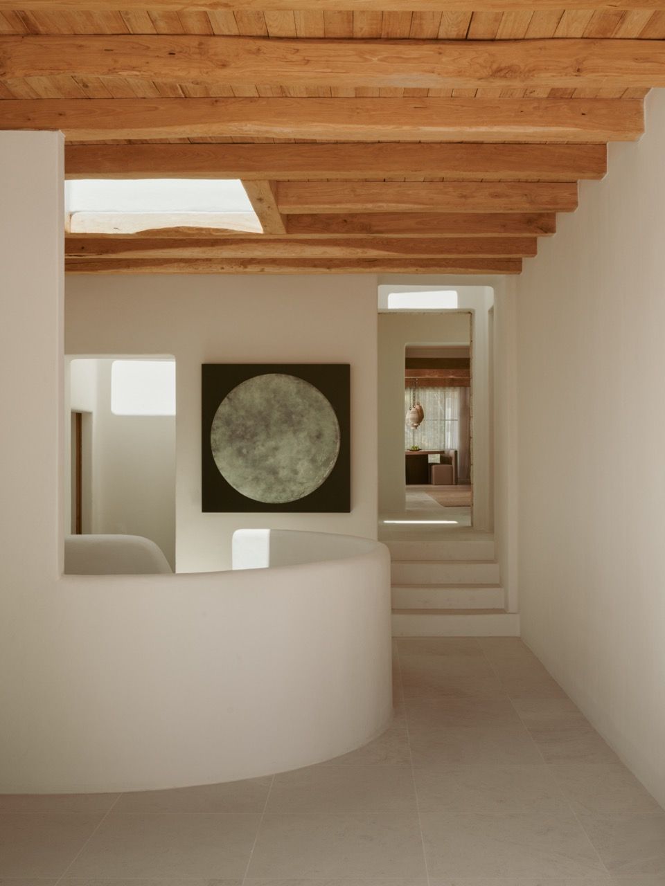 Exposed wooden beams overhead contrast with clean contemporary lines below, whilst artwork provides focal points in the carefully curated interior spaces