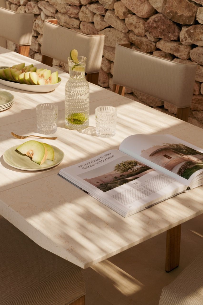 The outdoor dining area combines traditional stone walls with contemporary furniture, creating an authentic yet refined Mediterranean dining experience