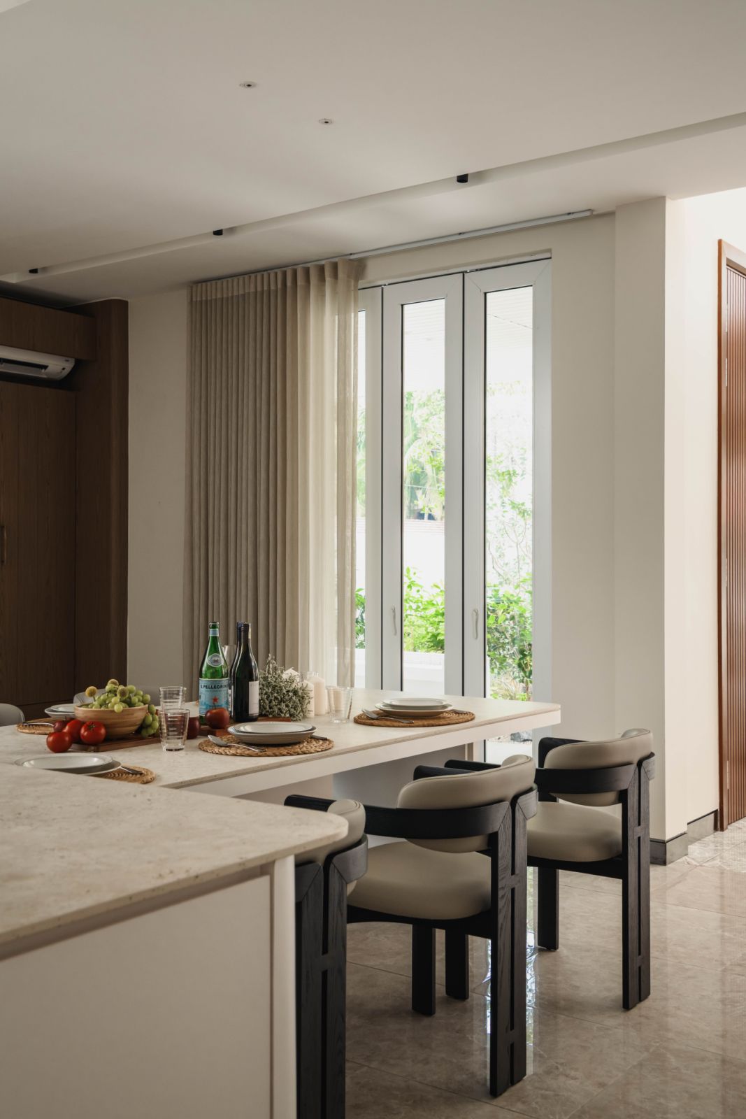 Kitchen and dining area with natural light streaming through windows, showing the curated landscaping outside that strengthens the connection with nature from within the interior