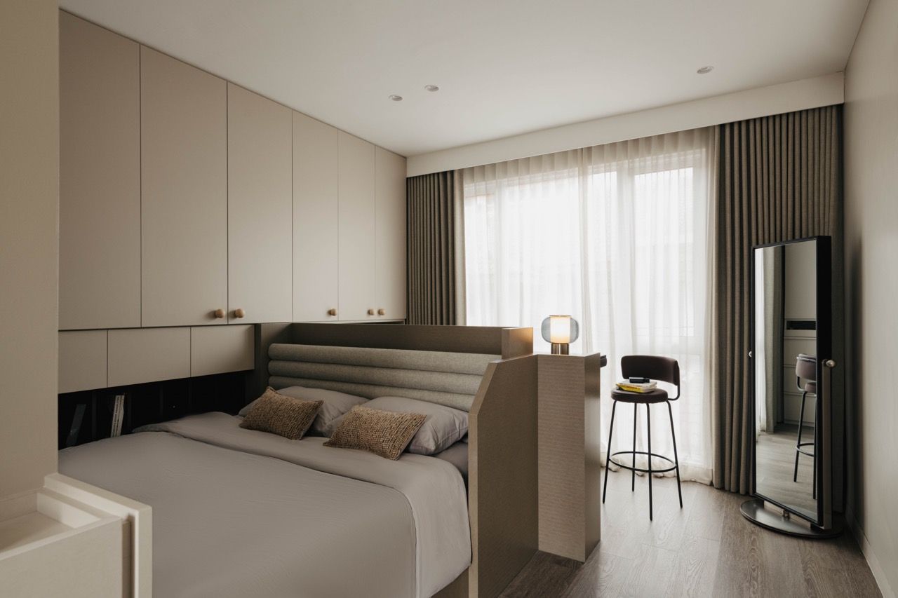 Another bedroom view with built-in storage and natural veneer finishes, showing how the material palette creates consistency throughout the home
