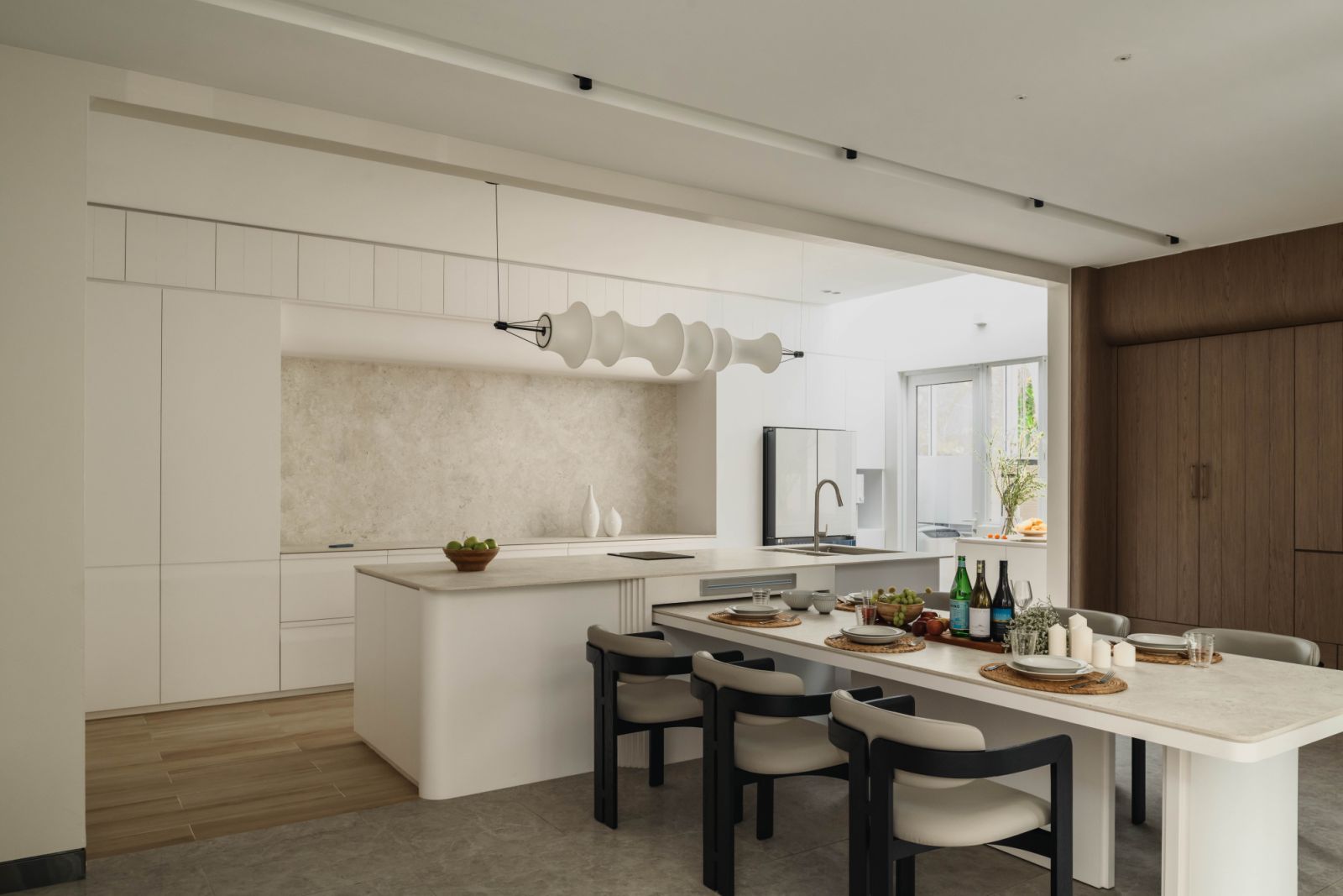 Kitchen island with matte finish cabinetry and natural stone surfaces, demonstrating the approach of minimising glossy finishes in favour of grounded, warm textures.