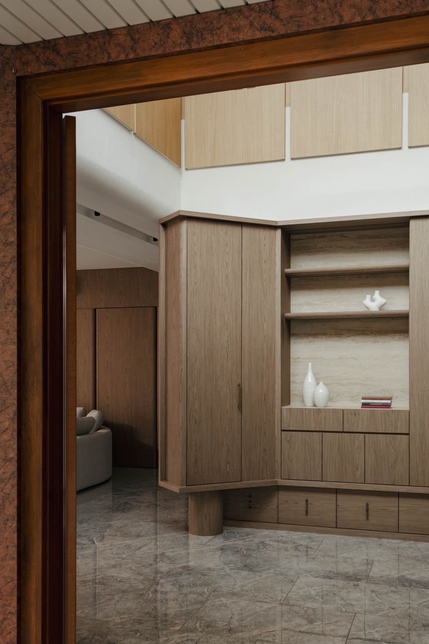 View through the double-volume void showing the upper level natural wood elements and the skylight system that eliminates the need for artificial lighting during the day
