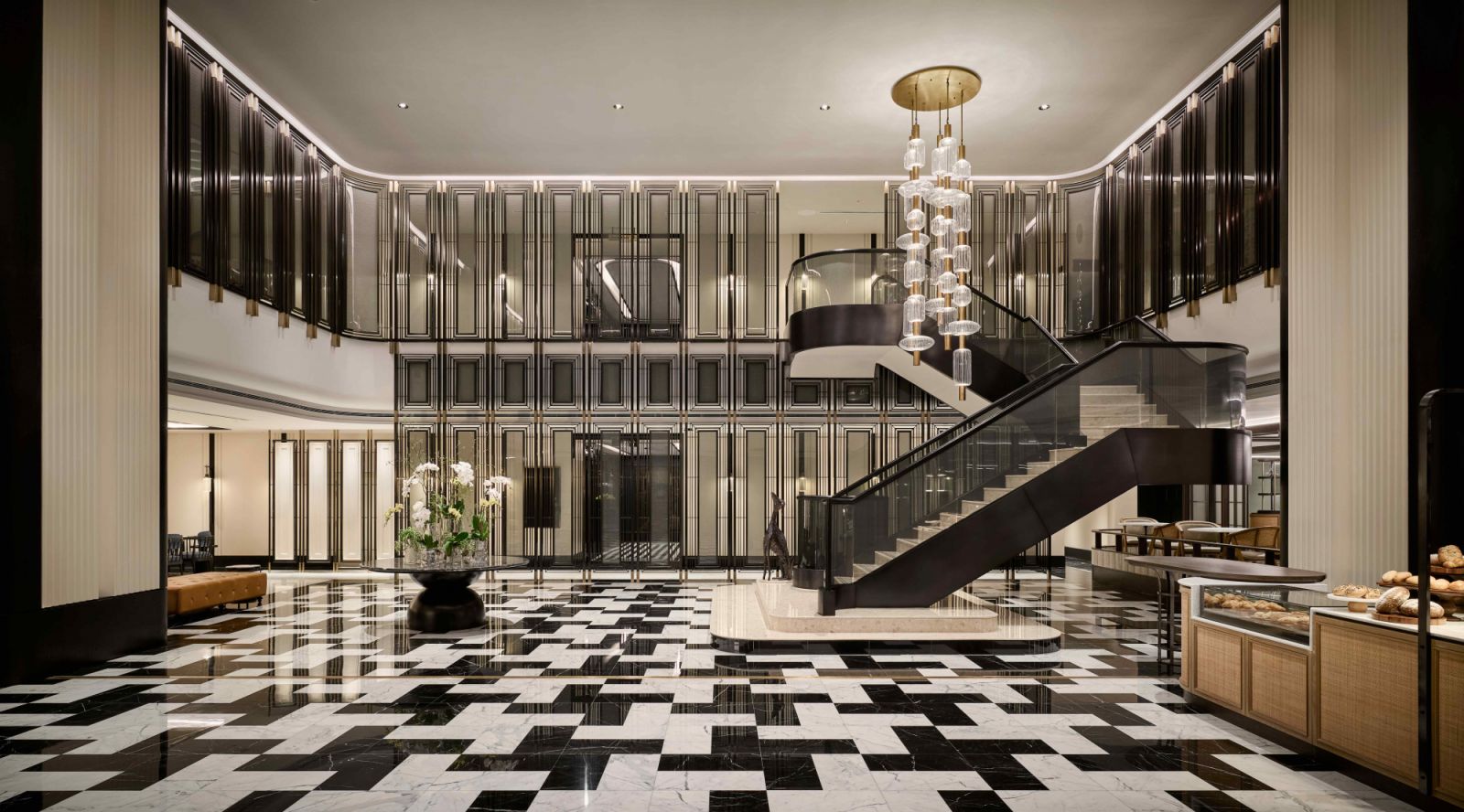 The grand lobby with a sweeping staircase crowned by a commanding chandelier, and polished black-and-white marble flooring (Photo: The Millen)